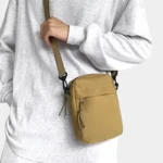 sac banane bandoulière homme beige porté de face style streetwear