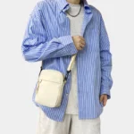 sac banane bandoulière homme blanc porté de face avec une chemise
