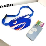 sac banane enfant garçon bleu vif avec un smartphone iphone à côté