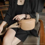 sac banane femme chic en cuir marron beige porté par la anse