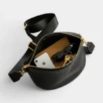 sac banane femme chic ouvert avec des affaires à l'intérieur