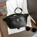 sac-banane-xxl-femme-cuir-graine-noir sac banane xxl femme cuir grainé noir posé sur une chaise