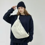 grand sac banane velours côtelé blanc cassé beige bandoulière femme style streetwear grand sac banane velours côtelé blanc cassé beige porté par une femme en bandoulière au style streetwear