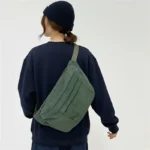 grand sac banane velours côtelé vert foncé bandoulière femme dos grand sac banane velours côtelé vert foncé porté par une femme en bandoulière dans son dos