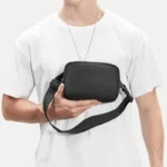 mini sac banane homme porté dans une main