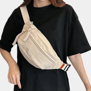 sac banane beige porté en banoulière par une femme habillée en noir