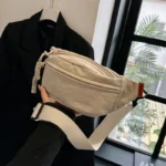 sac banane beige porté dans la main d'une femme