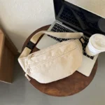 sac banane beige velours côtelé dimensions posé sur un macbook