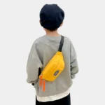 sac banane enfant 10 ans noir porté en bandoulière dans le dos par un garçon