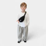 sac banane enfant 10 ans noir porté en bandoulière par un garçon