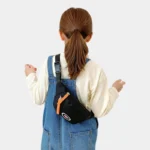 sac banane enfant 10 ans noir porté en bandoulière dans le dos par une fille