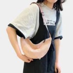 sac-banane-femme-velours-cotele-rose-pale-bandouliere-femme sac banane femme velours côtelé rose pâle porté en bandoulière par une femme