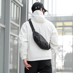 sac banane homme stylé noir carbone porté en bandoulière dans le dos