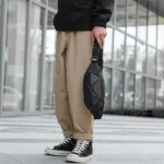 sac banane homme stylé noir carbone porté à la main