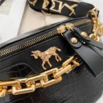 sac banane luxe noir avec une grosse chaine dorée à l'avant