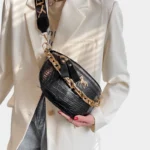 sac banane luxe noir porté en bandoulière par une femme