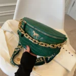 sac banane luxe vert sapin avec une grosse chaine dorée à l'avant