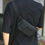 sac banane rectangulaire porté en bandoulière par un homme dans le dos