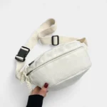 sac banane velours côtelé blanc cassé dans une main