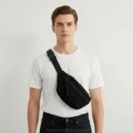 sac banane velours côtelé noir porté en bandoulière par un homme