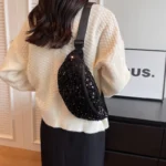 sac-banana-sequins-noirs-bandouliere-epaule-femme sac banana sequins noirs porté sur l'épaule par une femme