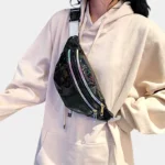 sac banane brillant noir avec des facettes colorées porté par une femme en bandoulière