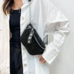 sac banane clouté noir porté sur l'épaule par une femme