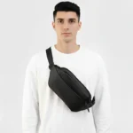 sac banane étanche noir porté en bandoulière par un homme