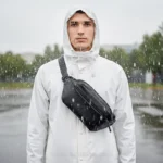 sac banane étanche noir porté en bandoulière par un homme sous la pluie