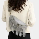 sac-banane-frange-gris-bandouliere-femme sac banane frange gris porté en bandoulière par une femme dans le dos