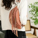sac-banane-frange-marron-western-bandouliere-epaule-femme sac banane frange marron porté sur l'épaule par une femme