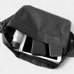 sac banane grand format noir rempli d'affaires avec un tablette et un parapluie