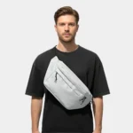 sac banane grand format gris clair porté en bandoulière par un homme