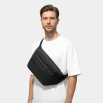 sac banane grand format noir porté en bandoulière par un homme