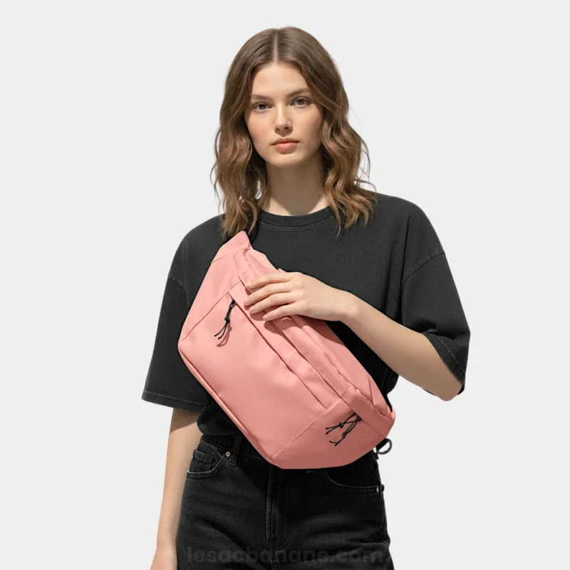 sac banane grand format rose saumon porté en bandoulière par une femme