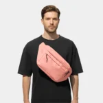 sac banane grand format rose saumon porté en bandoulière par un homme