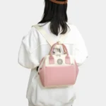 sac banane langer rose en mode sac à dos porté par une femme