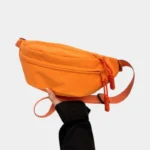 sac-banane-orange-main sac banane orange porté dans une main par une femme