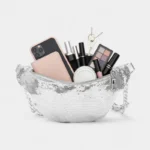sac banane paillettes argentées avec un smartphone des affaires et du maquillage dedans