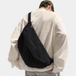 sac banane xl velours côtelé noir porté en bandoulière dans le dos par un homme