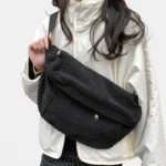 sac banane xl velours côtelé noir porté en bandoulière par une femme habillé en style streetwear