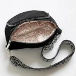 Sac Banane Bandouliere Velours noir ouvert montrant un intérieur à motif fleuri et une bandoulière décorée de motifs géométriques