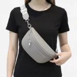 sac banane sangle interchangeable gris porté en bandoulière par une femme