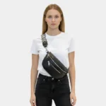 sac banane sangle interchangeable noir porté en bandoulière par une femme