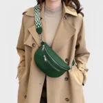 sac banane sangle interchangeable vert sapin porté en bandoulière par une femme chic