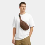 sac banane velours côtelé marron porté en bandoulière par un homme