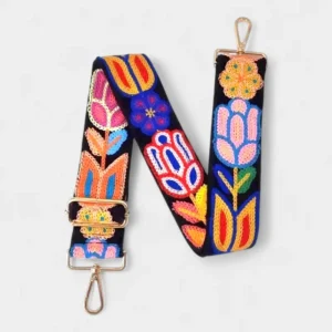 Bandoulière Brodée Bohème Motifs Floraux noire avec broderies fleurs multicolores et boucles en métal doré visible sur fond clair.