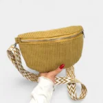 Petit Sac Banane Velours Côtelé Bandoulière Femme de couleur jaune porté dans une main