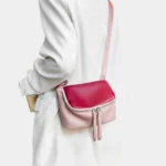 Sac à Main Banane Cuir Femme en cuir rose et rouge porté sur l'épaule avec une lanière