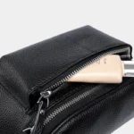 Sac Banane Bandoulière Femme Cuir Chic Poche Avant en cuir noir avec une fermeture éclair ouverte et un tube à l'intérieur